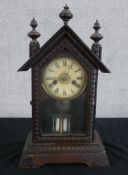 An early 20th century Junghans carved beech mantle clock, the white dial with black Roman numerals