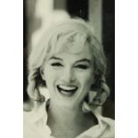 A framed black and white photograph of Marilyn Monroe smiling. H.61 W.47cm.