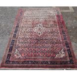 A red ground Persian woollen carpet with all over geometric pattern. H.290 W.215cm