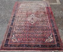 A red ground Persian woollen carpet with all over geometric pattern. H.290 W.215cm