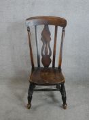 An 18th century style beech nursing chair with pierced splat back raised on splayed turned