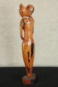 A contemporary carved African hardwood tribal figure of a kissing couple, raised on shaped plinth.