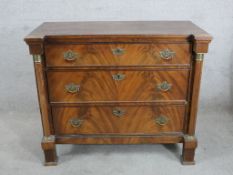 A 19th century mahogany chest of three long drawers, with brass swing handles, turned column