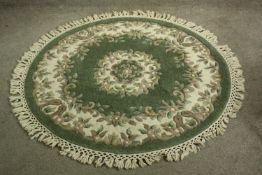 A contemporary green ground Chinese woollen circular rug with leaf decoration. Dia.140cm.