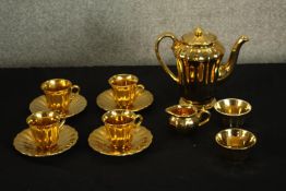 A Wade tea set with gilded decoration. Including a teapot, four cups with saucers, a creamer and two