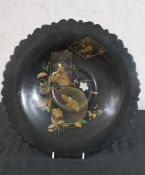 A late 19th/early 20th century Japanese black lacquered tazza decorated with a female in a garden