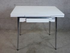 A mid 20th century Supamatic formica drawleaf dining table raised on chrome plated supports