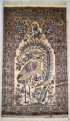 A Persian silk and wool tree of life rug, the ivory field with a crane and assorted flowers within a