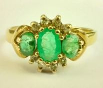 A 9ct gold emerald and diamond three stone cluster ring. Hallmarked: G&TJ, 375.