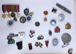 A collection of military badges and medals, including various enamel cap badges.