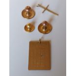 Four gold shirt stud backs, a 9ct gold pendant in the form of a calendar with a diamond set on one d