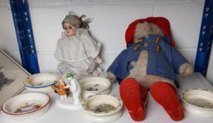 Paddington bear, a child's doll, and five children's bowls.