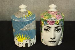 Two Fornasetti candles in decorated face pots. Part of the 'Profumi' range. Each measures 15 cm