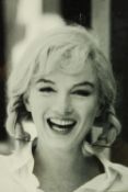 A framed black and white photograph of Marilyn Monroe smiling. H.61 W.47cm.