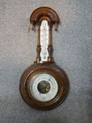 A late 19th century carved oak wall hanging aneroid barometer. H.40 W.22cm