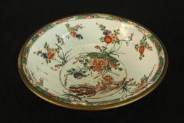 A 19th century Famille vert porcelain Chinese bowl with a floral pattern and brass rim. Diameter