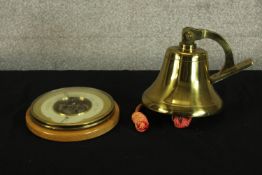 A brass ships style bell, together with a beech framed circular aneroid wall barometer. H.19cm. (