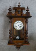 A 19th century mahogany cased Vienna type wall clock. the white dial with black Roman numerals. H.76