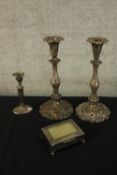 A pair of repousse foliate design silver plated candle sticks along with a smaller one with