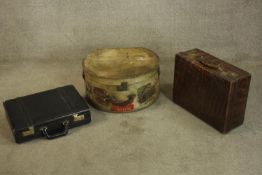 A hat box, crocodile skin case and black briefcase. The hat box with a yellow inlay and with a
