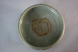 A possibly Ming period Chinese Longquan celadon glazed 'trigrams' bowl on three scrolling design