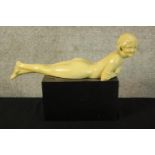 An Art Deco style figure. A reclining nude. Painted plaster. H.25 W.36cm.