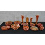 A collection of orange carnival glass. Fourteen pieces of varied size and shape. 27 cm largest.