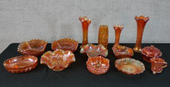 A collection of orange carnival glass. Fourteen pieces of varied size and shape. 27 cm largest.