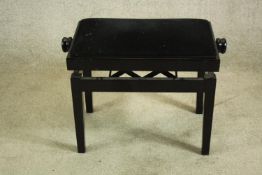 A black lacquered adjustable piano stool. H.48cm