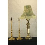Three brass lamps. One Rococo in style and with a shade and a pair probably Edwardian. H.86cm (