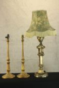 Three brass lamps. One Rococo in style and with a shade and a pair probably Edwardian. H.86cm (