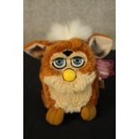 A vintage Furby toy complete with its tag. H.16 x W.10 cm.