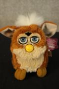 A vintage Furby toy complete with its tag. H.16 x W.10 cm.