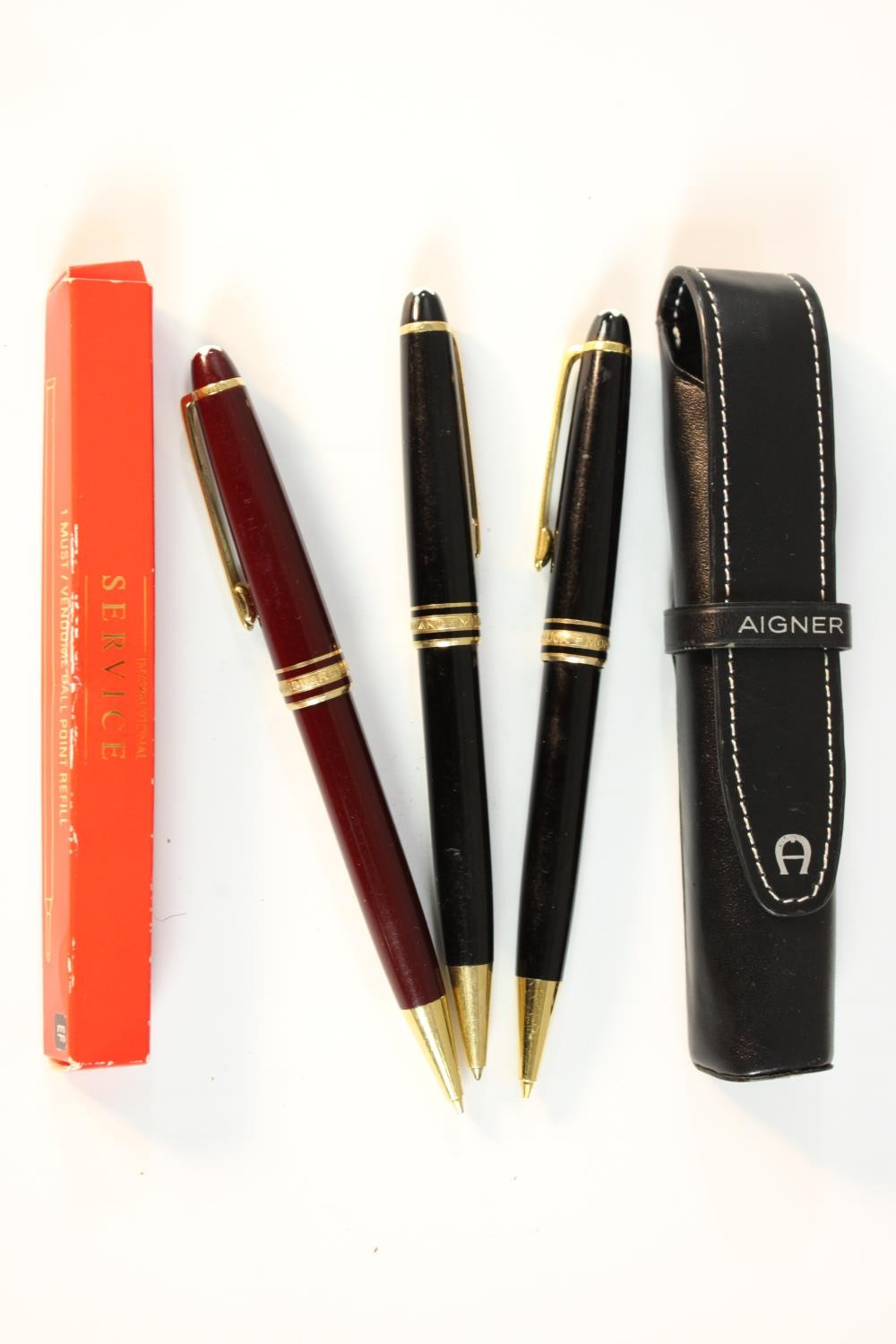 Three Mont Blanc Meisterstuck black lacquer ballpoint pens with gold plated detailing along with a