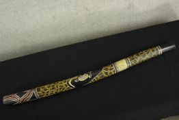 A heavily decorated Aboriginal didgeridoo. L.122 cm.
