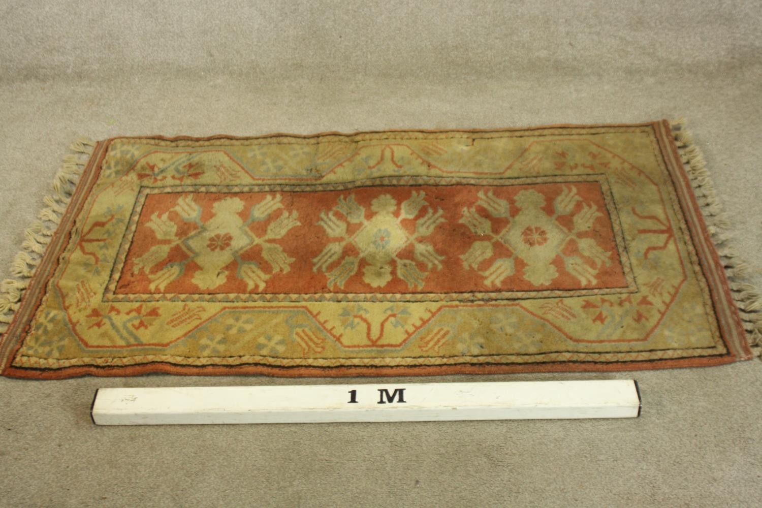 A Persian rug with repeating floral medallions on a terracotta ground. L.146 W.84cm. - Image 2 of 3