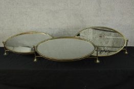 A set of three gilt metal wall fitting swing mirrors. H.37 W.67cm. (each)