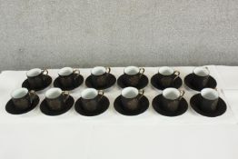 Twelve S Damage 20th century black painted coffee cups and saucers with gilded marks to base. H.6