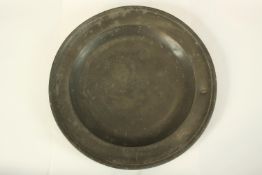 A pewter charger, quite deep and nicely aged. Early to mid nineteenth century. Dia.34 cm.