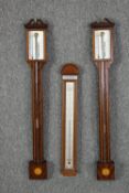 A pair of Georgian style stick barometers in mahogany cases along with another barometer. 100cm
