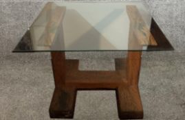 Dining table, plate glass top with heavy exotic hardwood base, probably stinkwood. H.76 W.100cm.