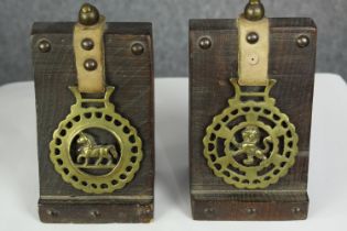 Two horse brasses with leather straps and mounted on wooden display stands. Each H.17 cm.