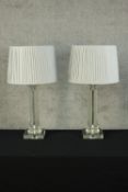 A pair of 20th century clear perspex and glass column design table lamps with white silk shades. H.