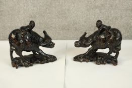 Two well carved Water Buffalo with 2 figures riding on their back. Aged with a good patina. each H.