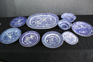 A mixed collection of blue and white patterned bowls and a platter. A varied mix of styles including