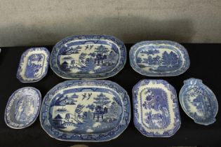 A collection of blue and white platters. Decorated with traditional Chinese pagoda and trees. And