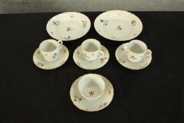 A 19th century hand painted tea set made up of three cups and saucers, a sugar bowl and two