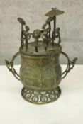 A bronze Ashanti ceremonial vessel. The lid populated with six figures, the largest is seated