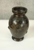 A Japanese Meiji period bronze vase with raised floral design and engraved foliate motifs.