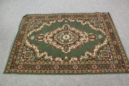 A Persian style woollen rug with intricate green pattern design. L.167 x w.120 cm.